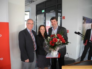 Michael Thews übergibt Yasmin Fahimi zusammen mit Rolf Möller als kleines Danke Schön neben einem Schrauberset noch ein Strauß Blumen